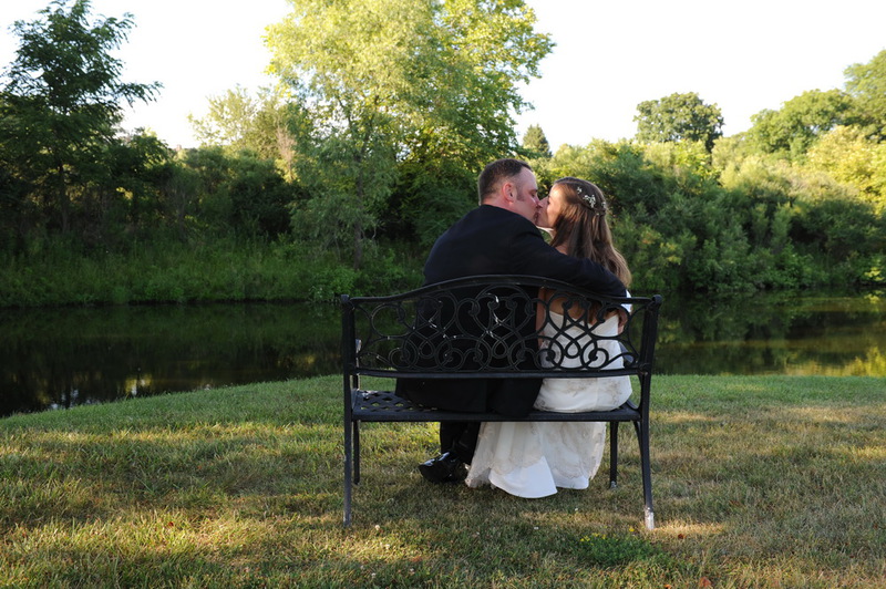 A couple on a garden bench beside a pond